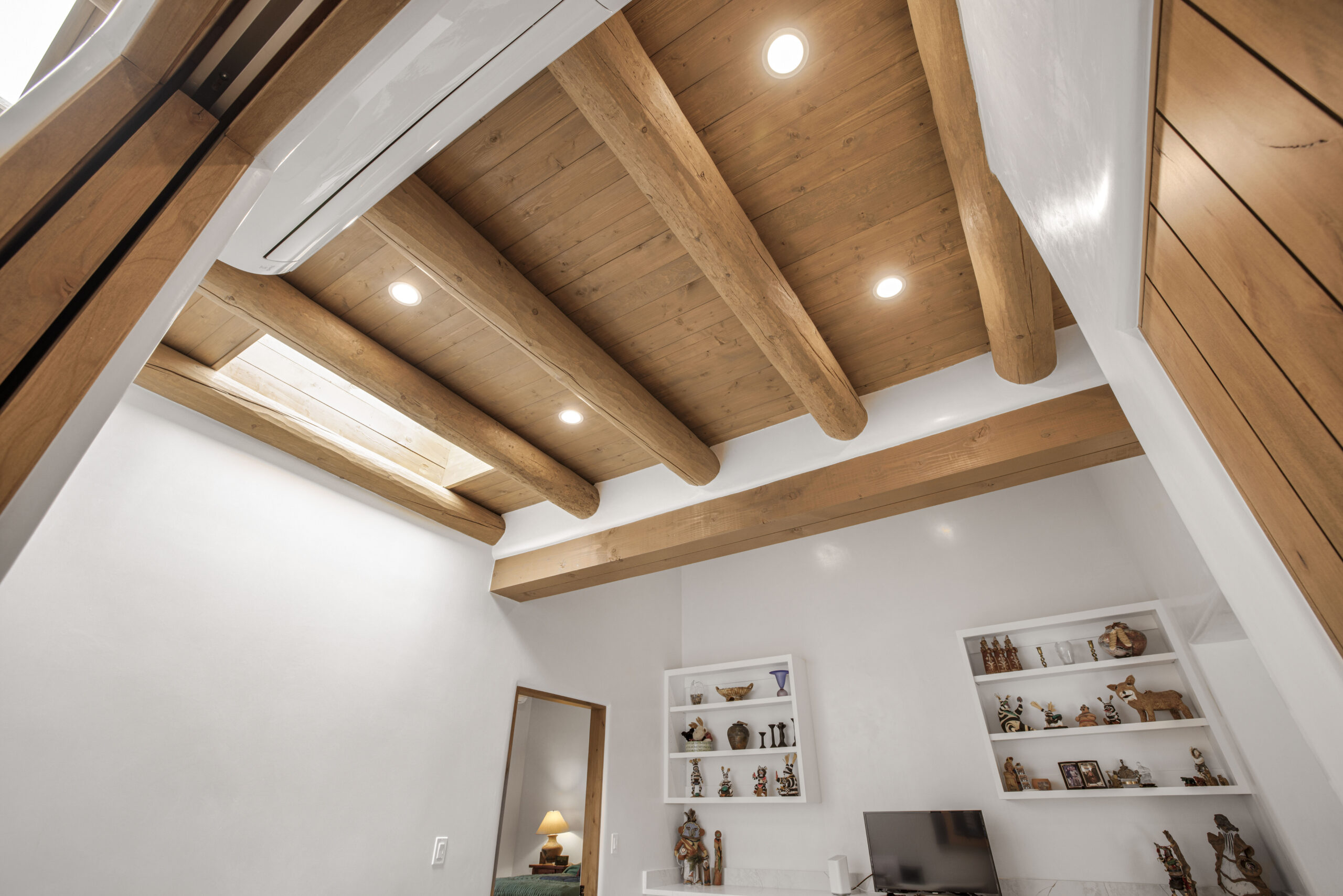 Modern ceiling with wooden beams and recessed lights in a stylish room.