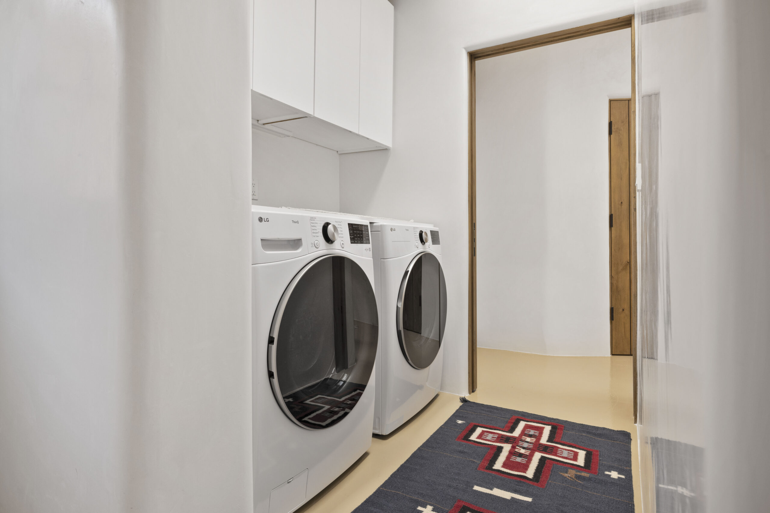Modern laundry room with white washer and dryer units.