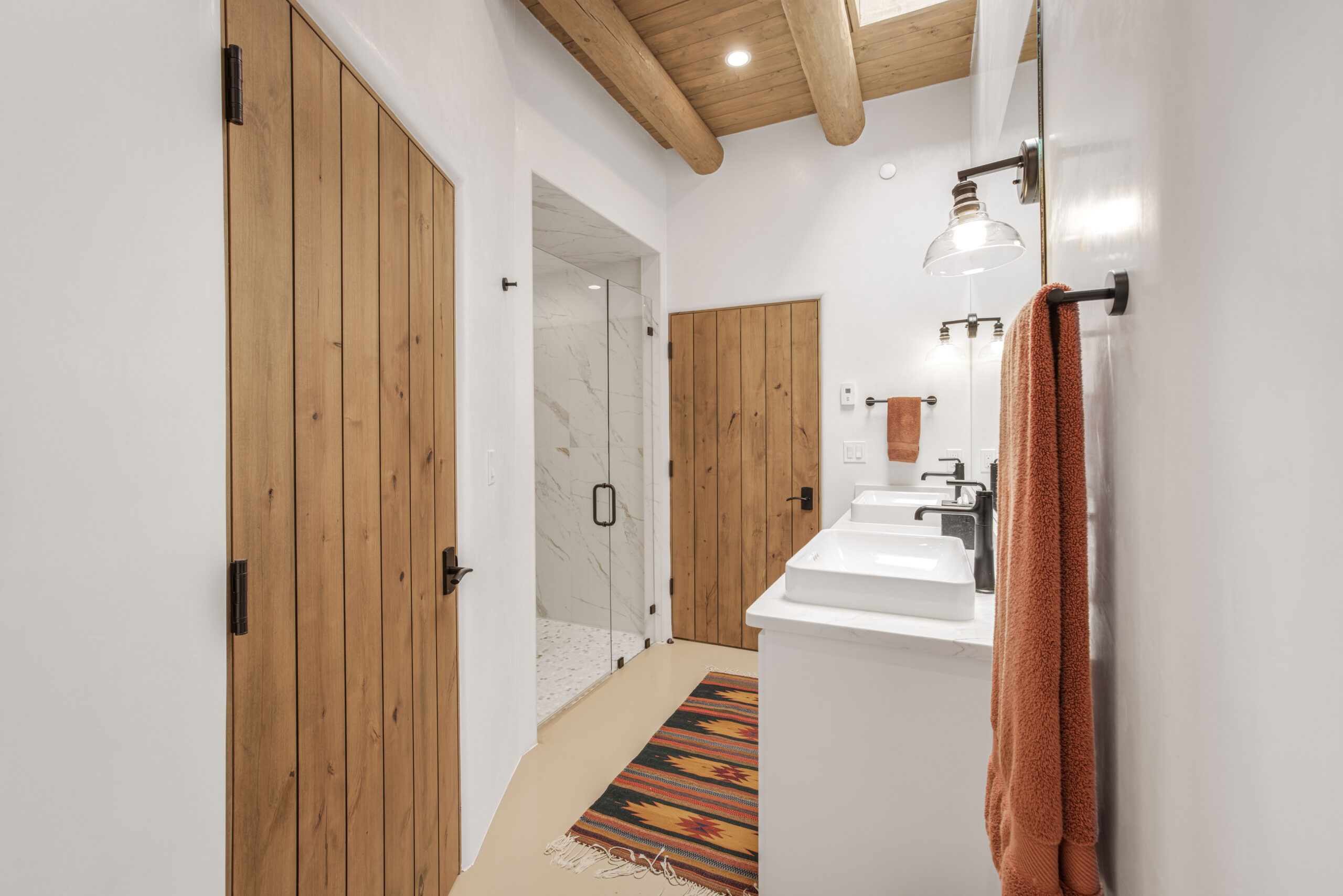Modern bathroom with wood accents and white fixtures.