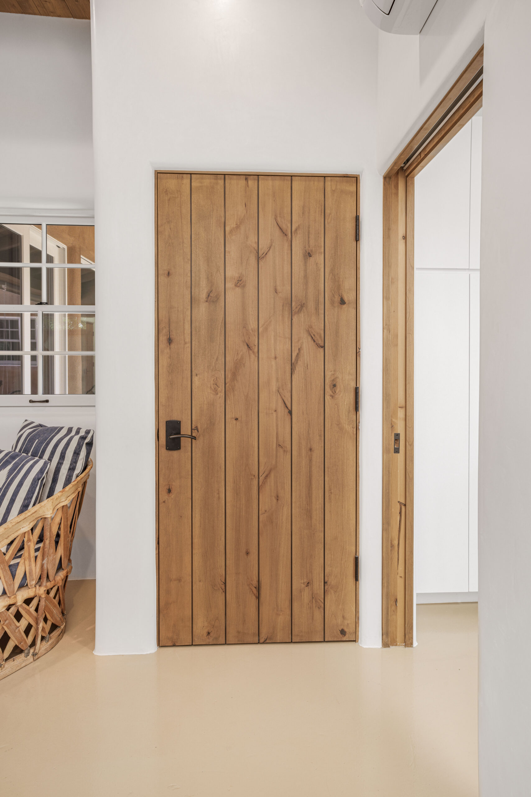 Rustic wooden door with black handle in a cozy interior.