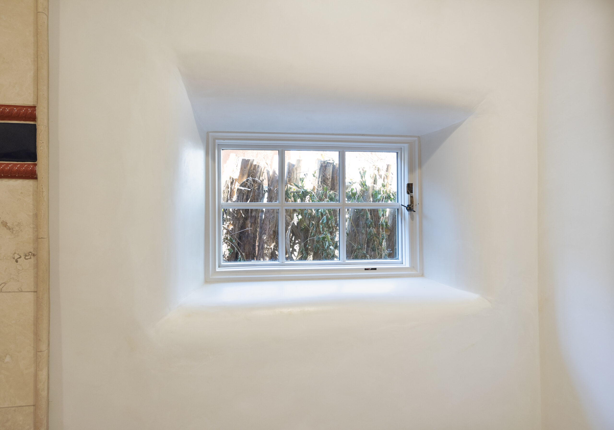 Small window with a view of trees outside.