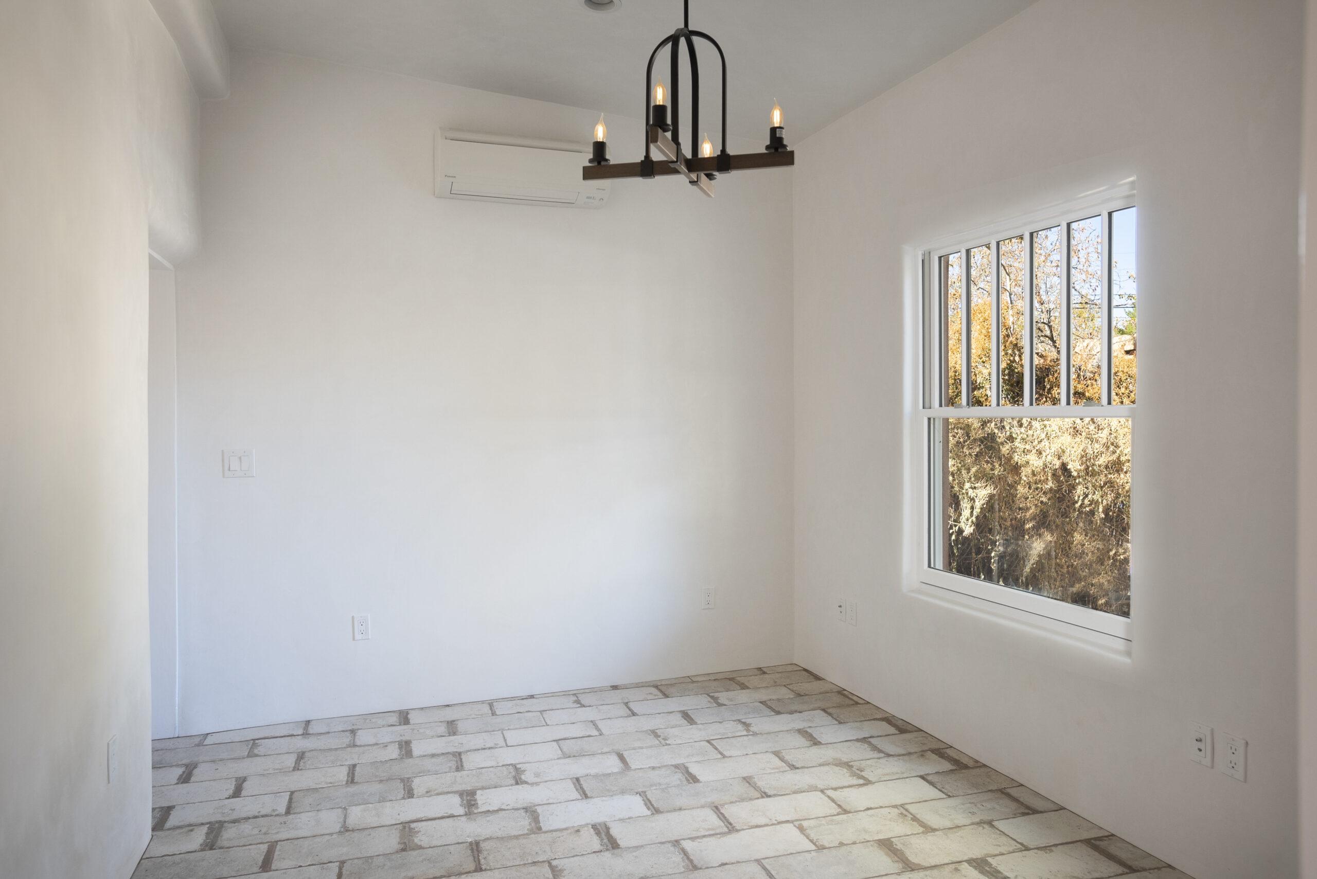 Empty room with tiled floor and chandelier above.