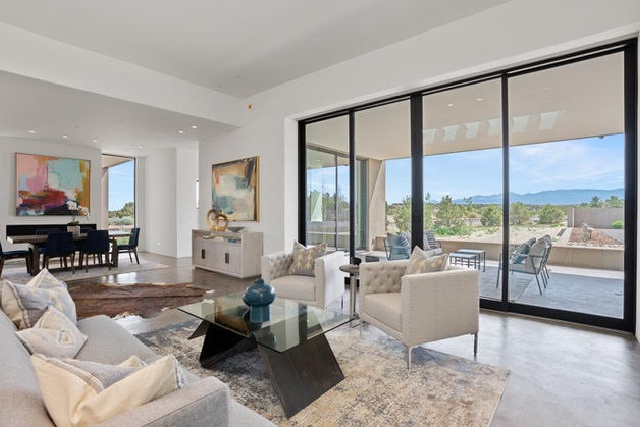 Bright modern living room with large glass doors and scenic mountain views.