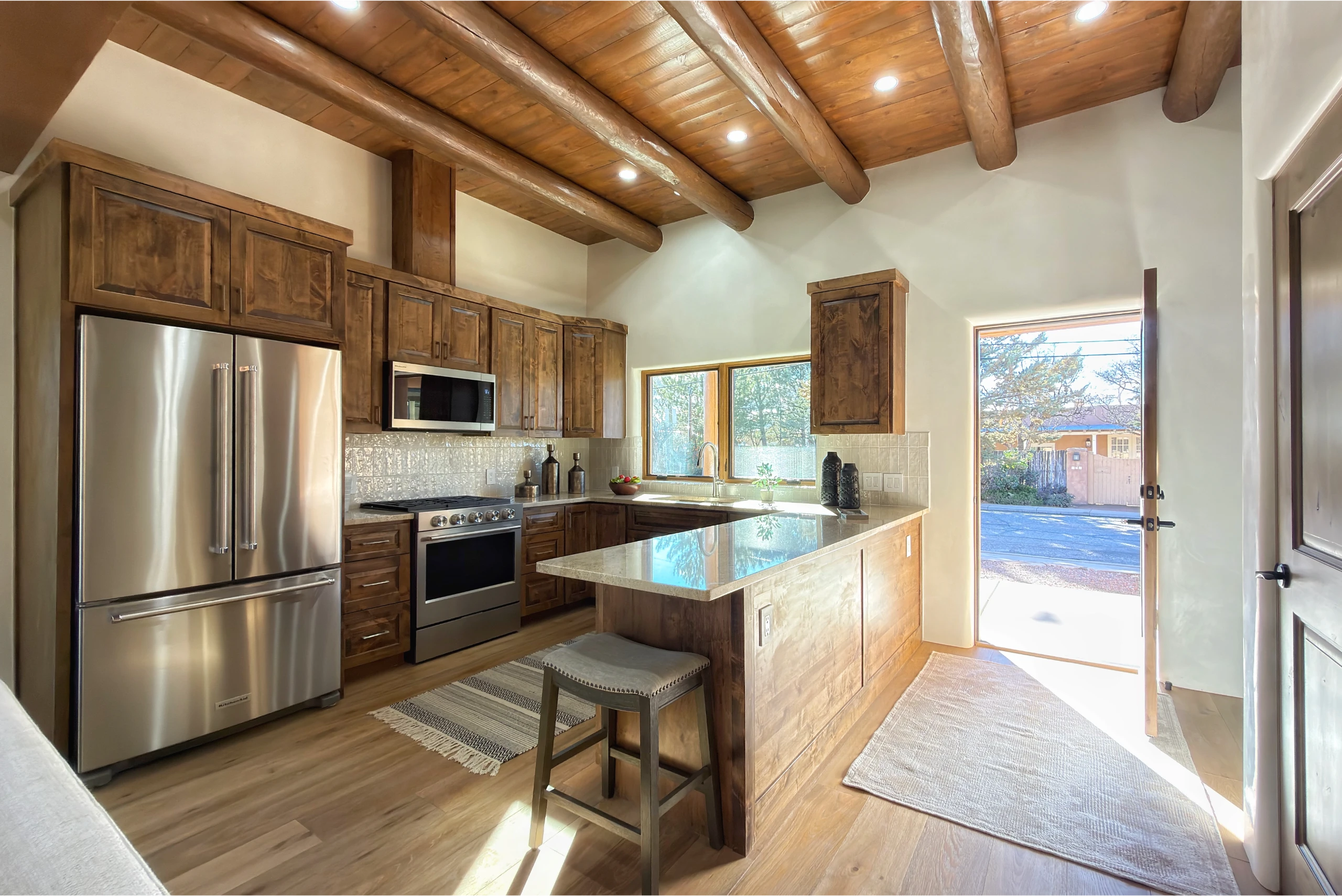 Bright modern kitchen with wooden beams and island seating.