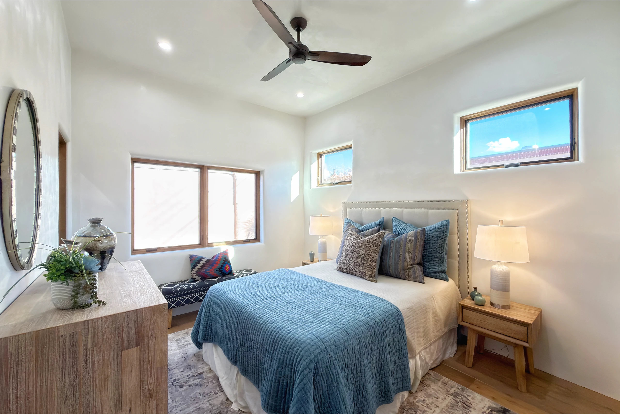 Bright, cozy bedroom with blue bedding and wooden furniture.