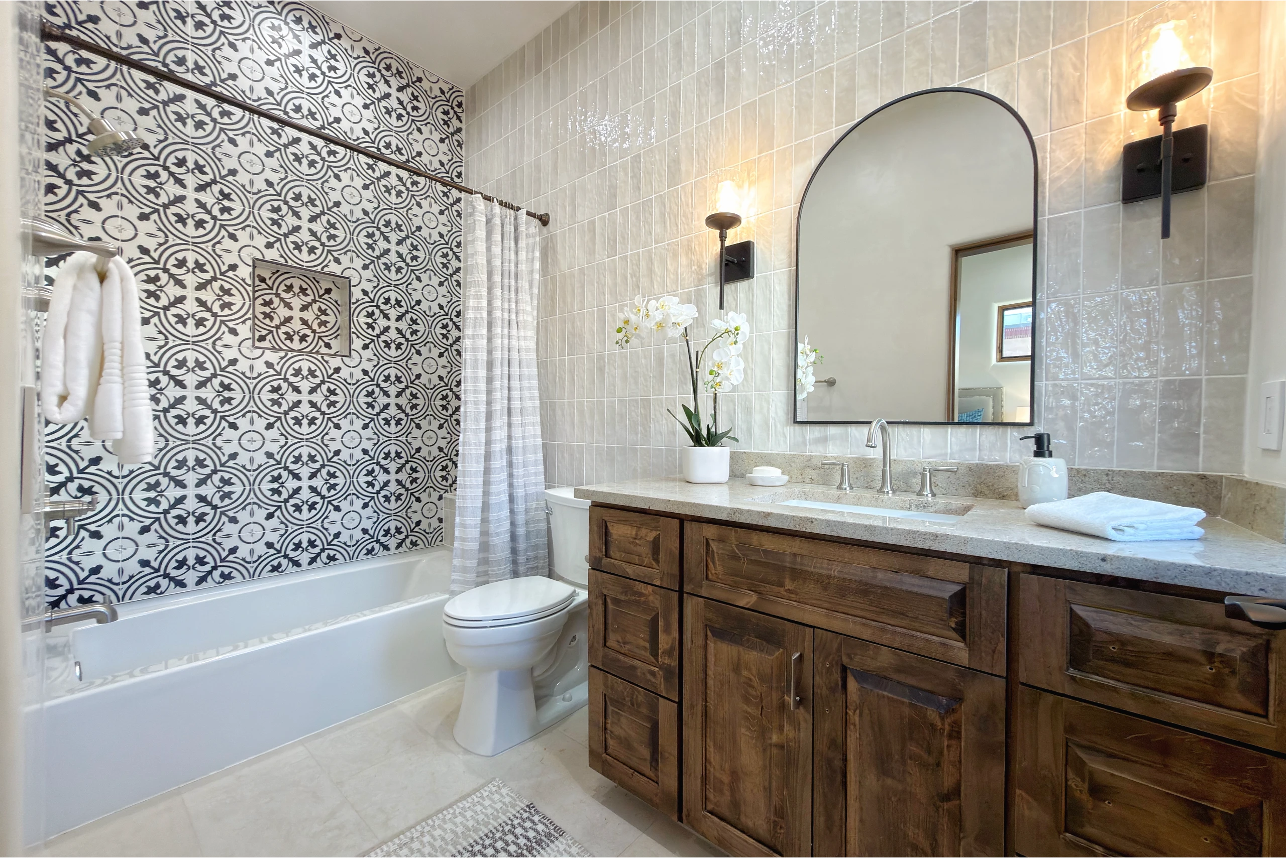 Modern bathroom with patterned tiles and wooden vanity.