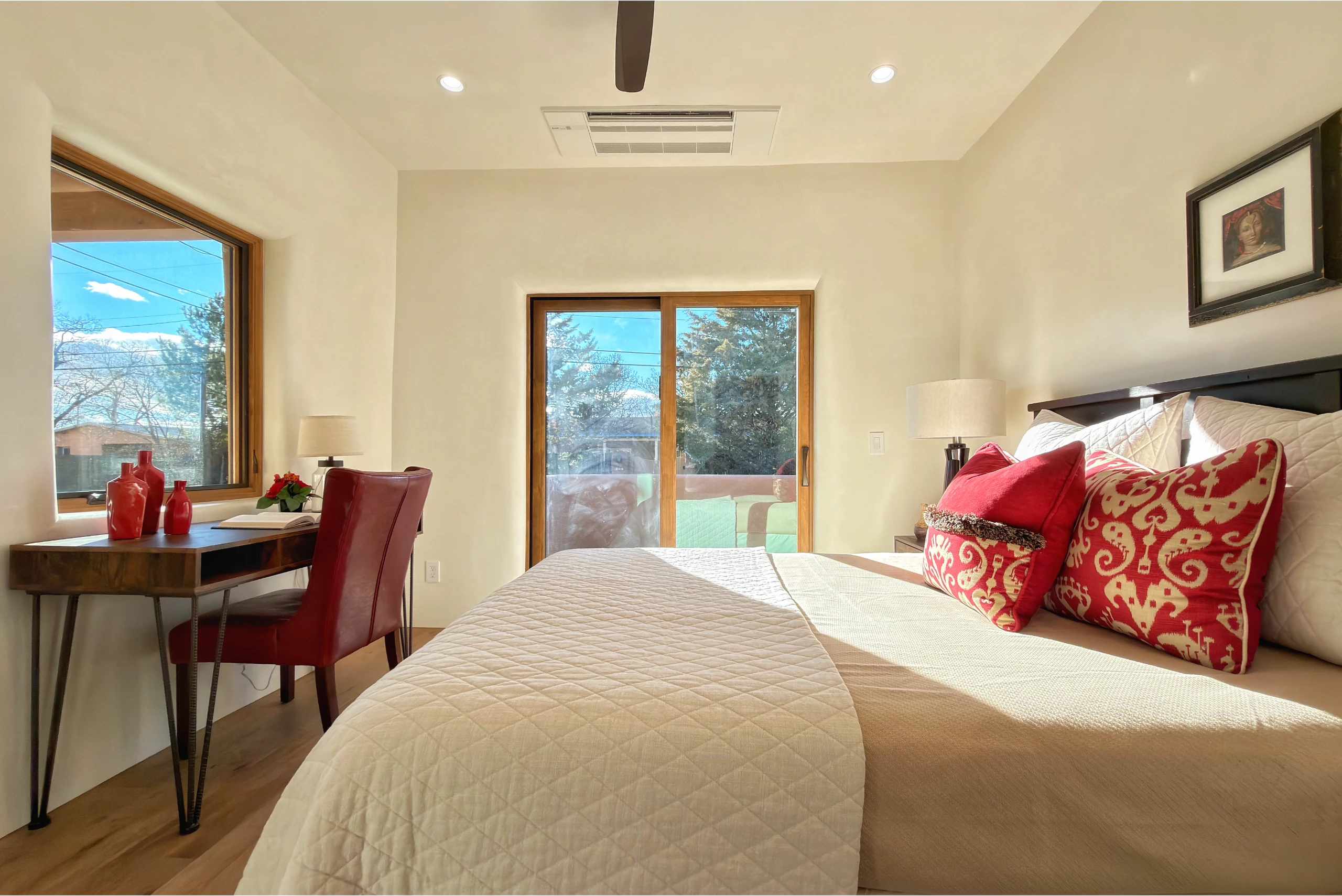 Bright bedroom with a large bed and sliding glass doors.