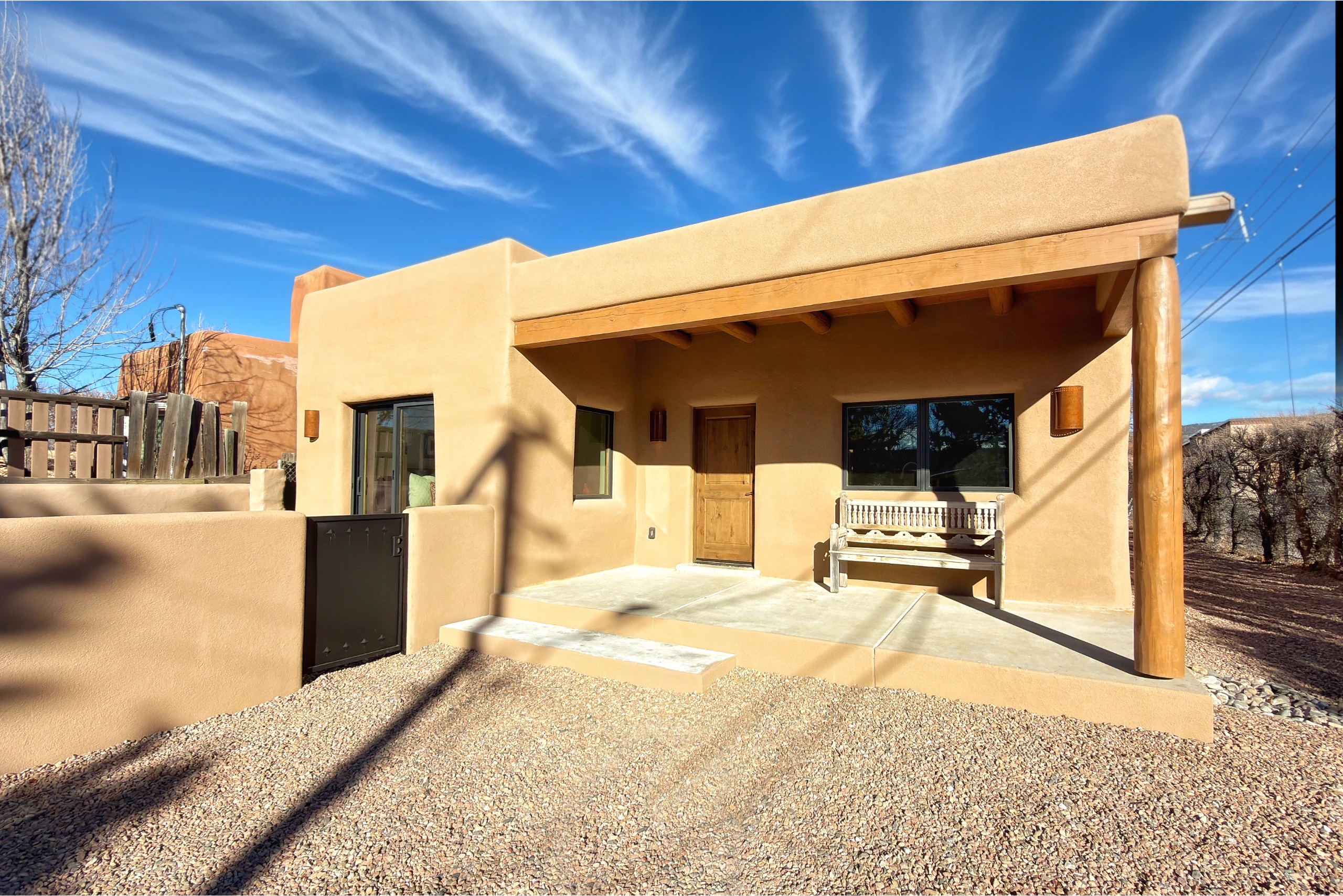 Modern desert home with a spacious patio under a bright blue sky.
