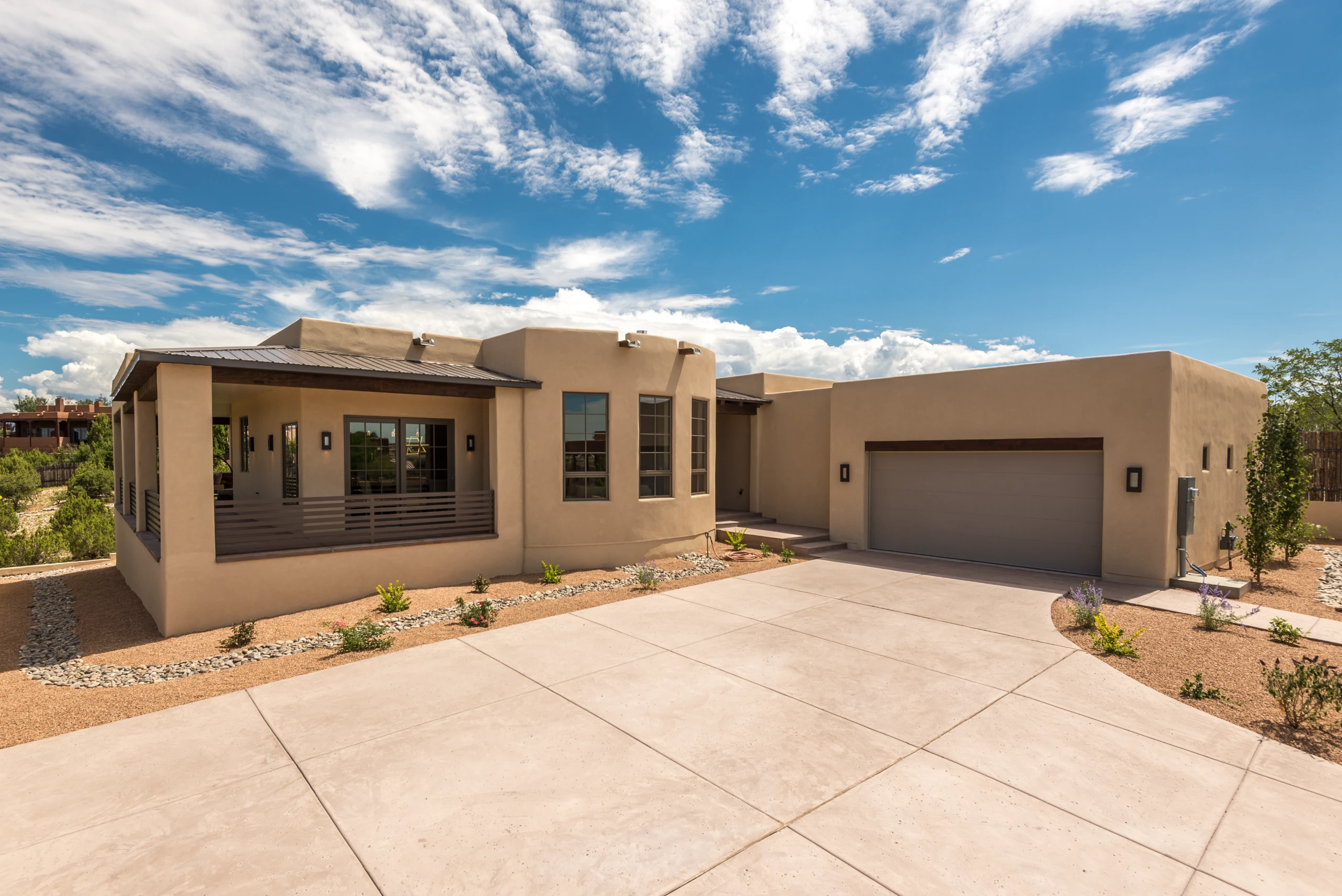 Modern single-story home with a spacious driveway and clear blue sky.